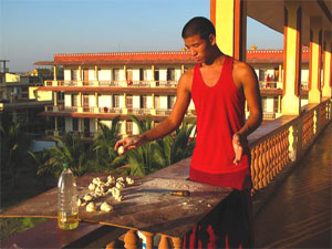 monk prepares food on balcony of Tsawa Khamtsen